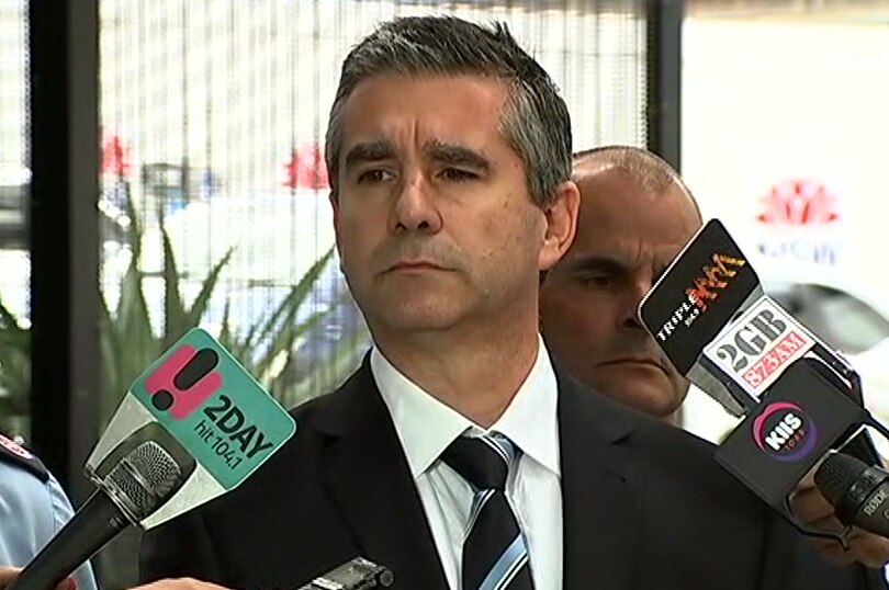 A man speaking in front of media microphones