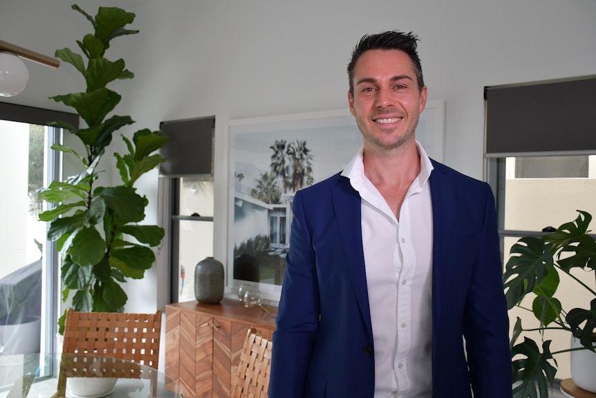 Brisbane City Council certified town planner Aaron Sweet stands in an office.