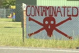 A sign shows a red scull and bones and reads "contaminated".