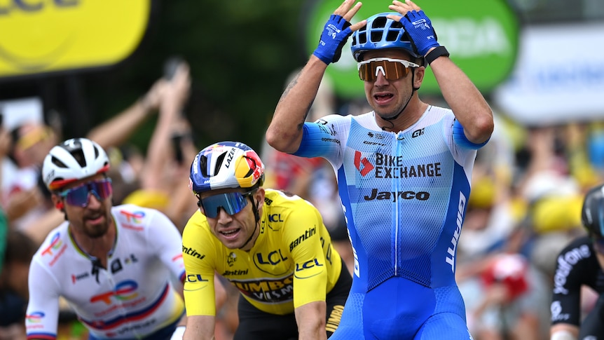 Dylan Groenewegen holds his hands to his head as he finishes narrowly ahead of the pack