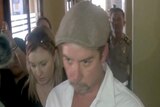 Anthony Connor surrounded by media and police during a visit to Denpasar police station to visit his ex-wife Sara Connor.