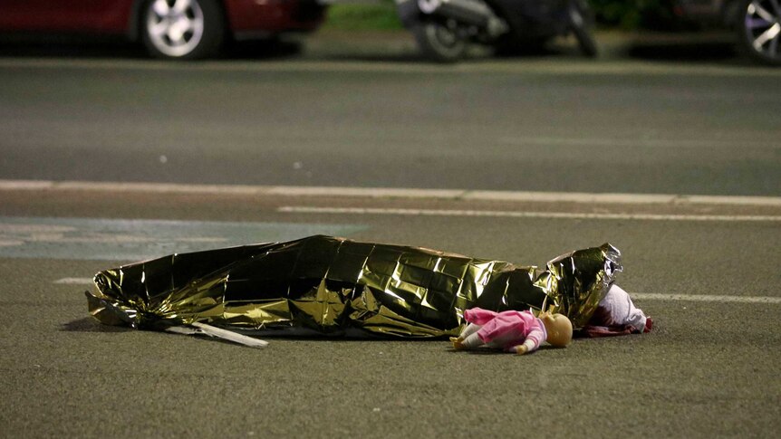 A body is seen on the ground July 15, 2016 after at least 30 people were killed in Nice, France, when a truck ran into a crowd celebrating the Bastille Day national holiday July 14