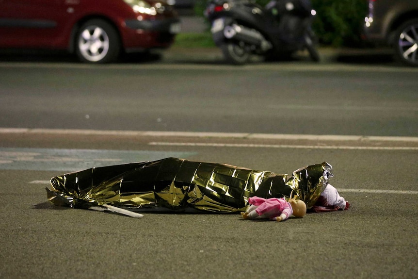 A body is seen on the ground July 15, 2016 after at least 30 people were killed in Nice, France, when a truck ran into a crowd celebrating the Bastille Day national holiday July 14