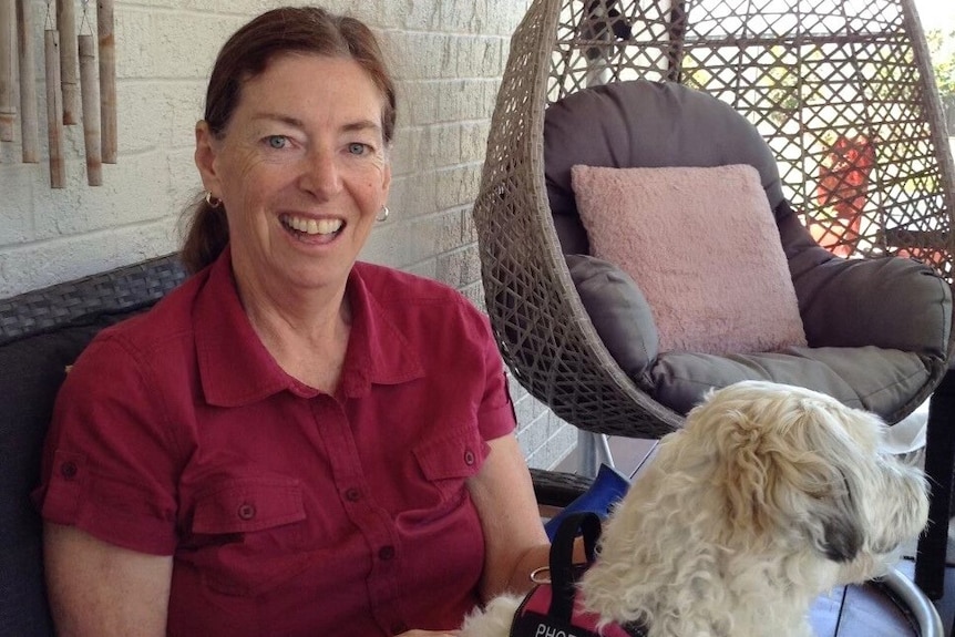 A photo of a woman smiling with a dog on her lap