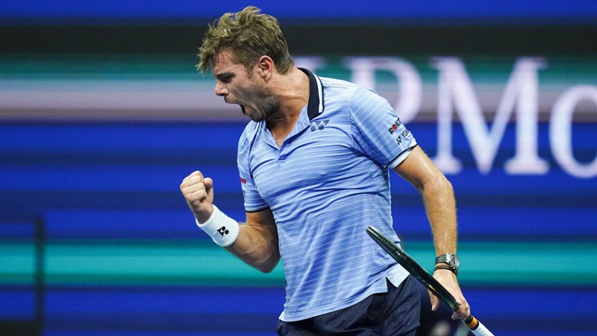 Stan Wawrinka clenches his right fist and screams, holding his racquet in his left hand