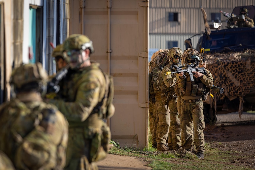 Soldiers prepare to enter a room as part of a military training exercise