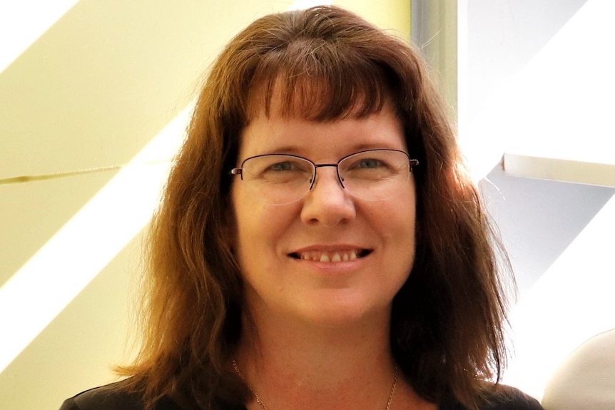 Headshot of smiling woman in dark top