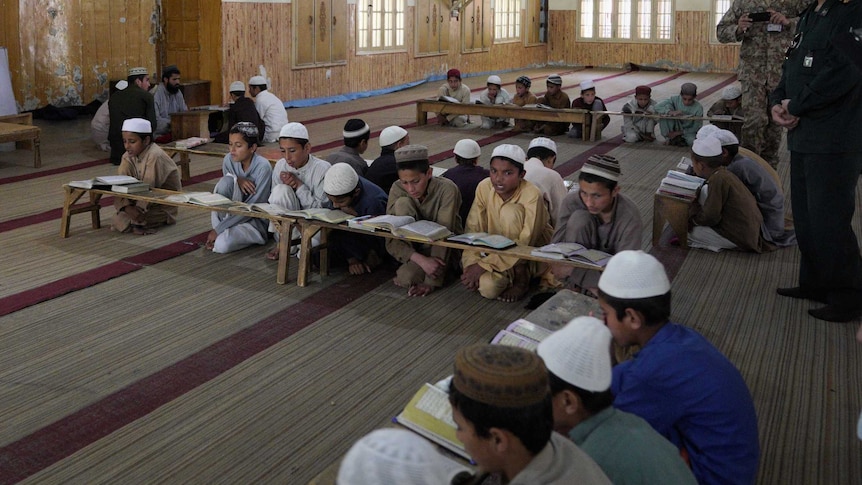 Little boys reading the Koran on the floor