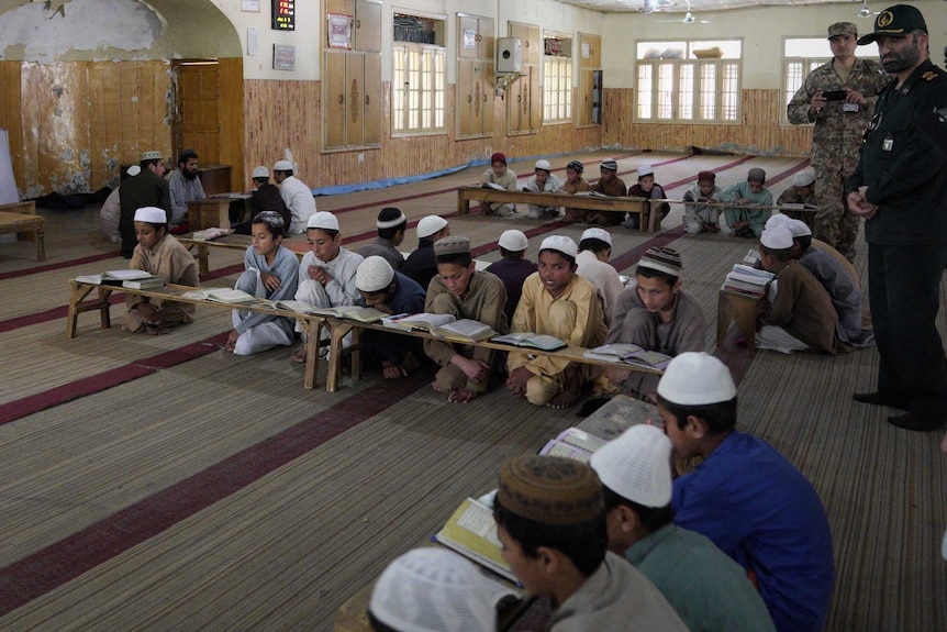 Little boys reading the Koran on the floor