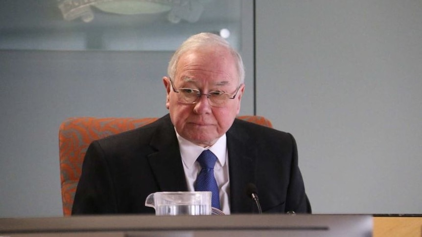 Bruce Lander sits at a desk with a microphone.