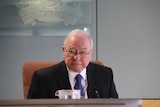 Bruce Lander sits at a desk with a microphone.
