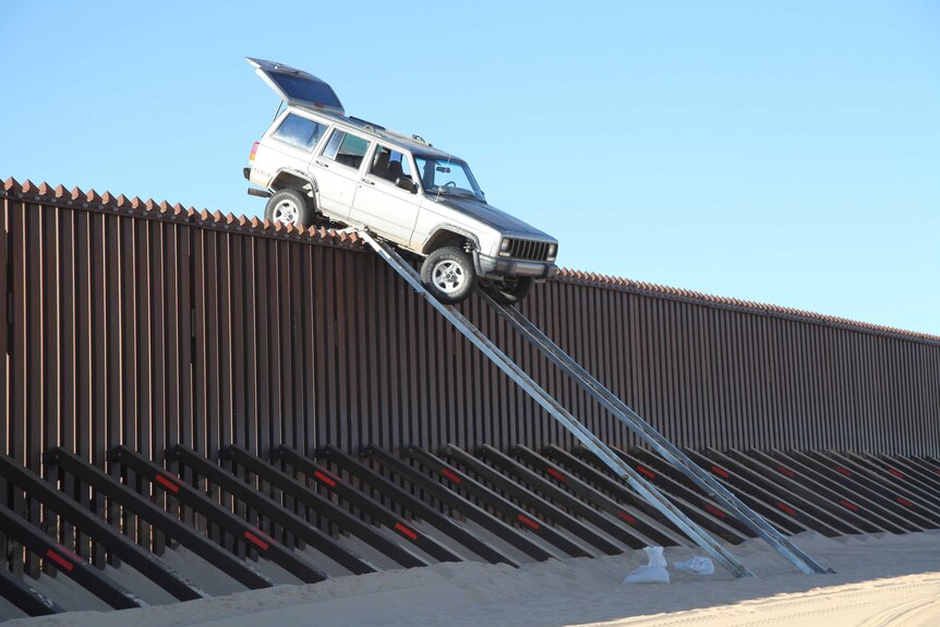 Car stuck atop US-Mexico border fence