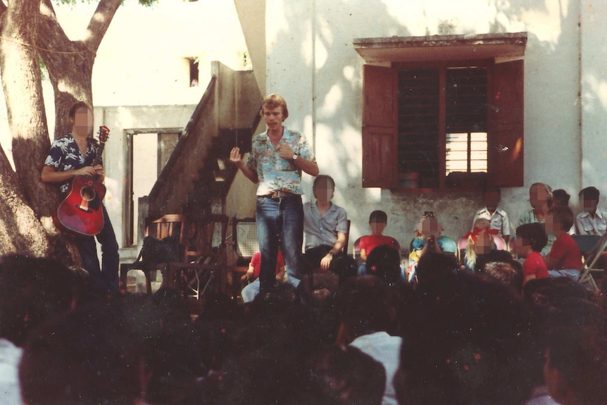 Tore Klevjer speaks to a seated crowd, outside a school in India.