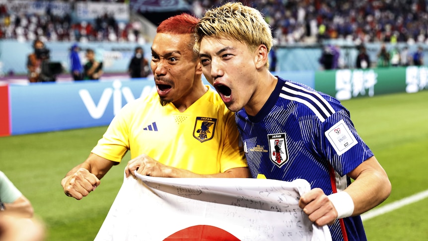 Ritsu Doan and Yuto Nagatomo hold a Japanese flag