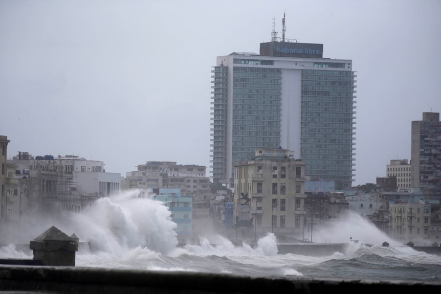 Waves surge over a sea wall in Havana, Cuba, almost reaching the height of some of the buildings in the city.