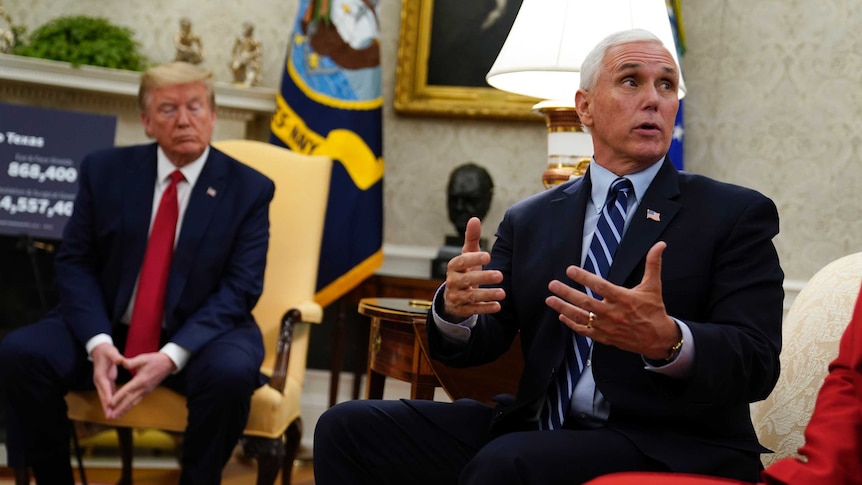 President Donald Trump listens as Vice President Mike Pence speak as they sit on lounge chairs.