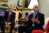 President Donald Trump listens as Vice President Mike Pence speak as they sit on lounge chairs.