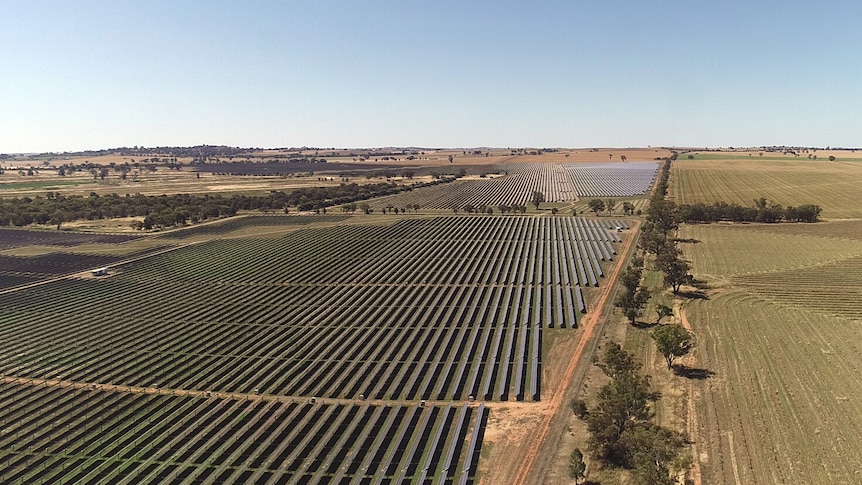 An aerial photo of a solar farm surrounded by farm land.