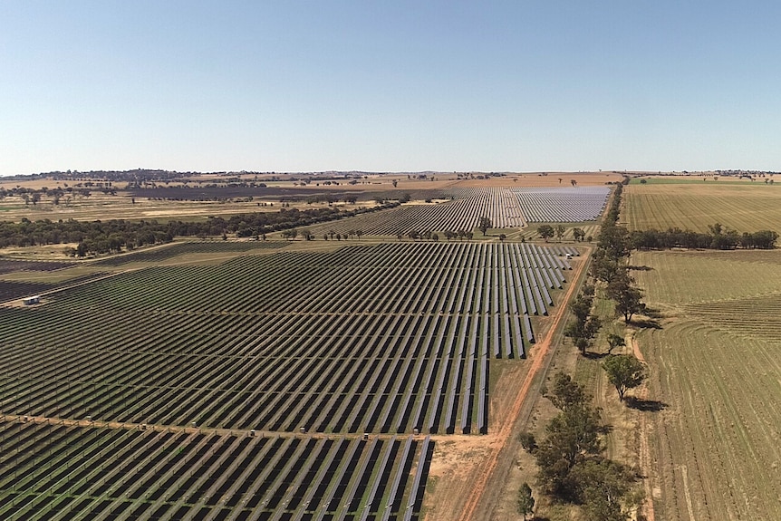 An aerial photo of a solar farm surrounded by farm land.