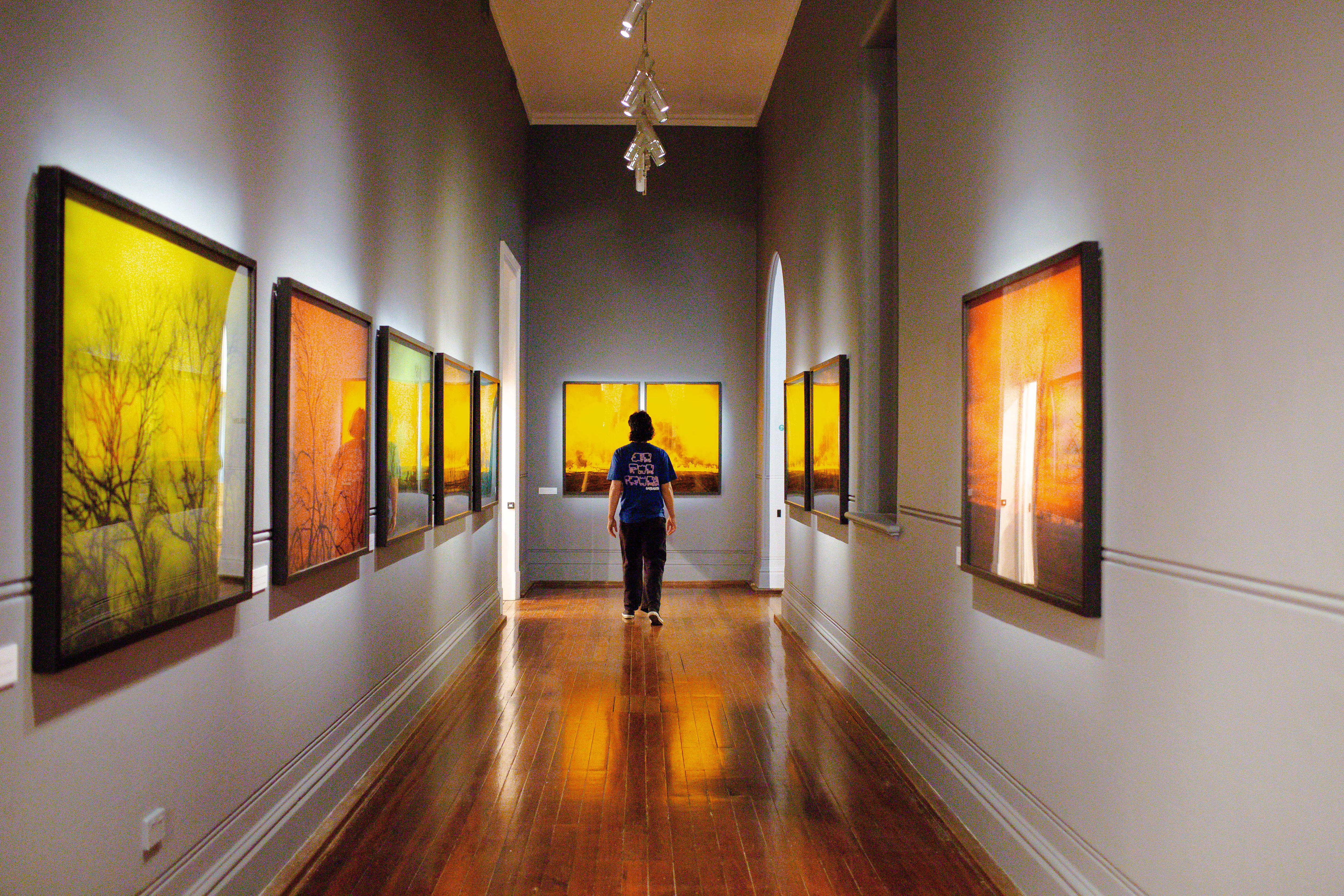 Darkened corridor with series of black and white images overlaid with deep colour