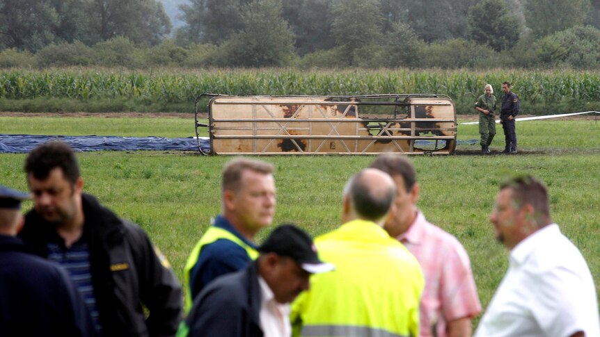 Police officers stand near a hot-air balloon that crashed in Slovenia.