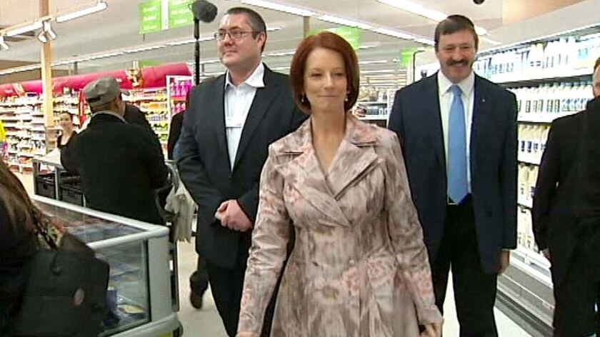 Prime Minister Julia Gillard walks through a Coles supermarket