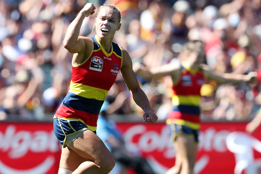 AFLW star Erin Phillips pumps her fist in celebration as she looks to the crowd after kicking a goal in the grand final.