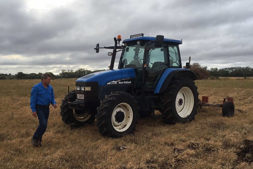 Frank Ashman next to a blue tractor
