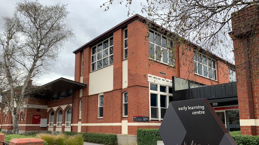 a red brick double storey building with a grey early learning centre sign