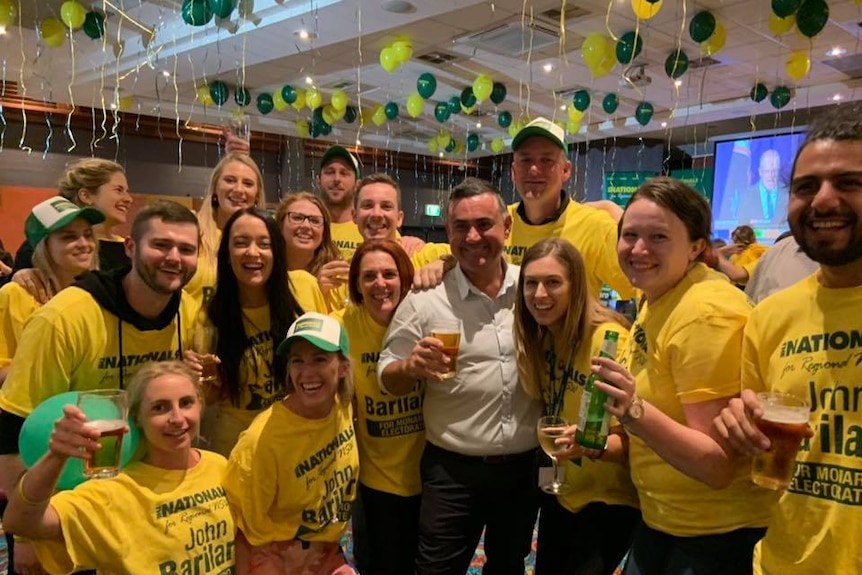 A group of people wearing yellow t-shirts stand in a line.