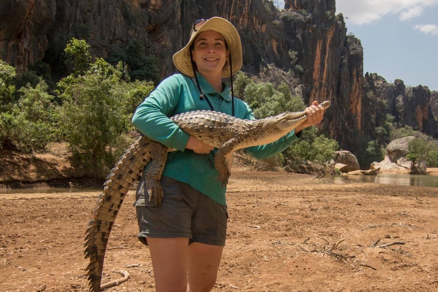 Young scientist holding young fresh water croc