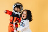 Two children play in astronaut outfits
