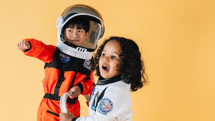Two children play in astronaut outfits