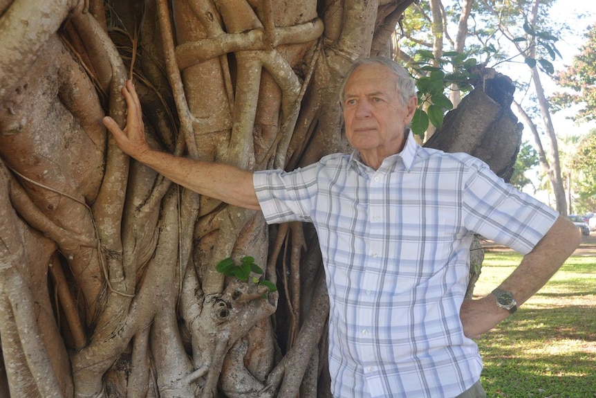 Marshall perron leans against a tree.