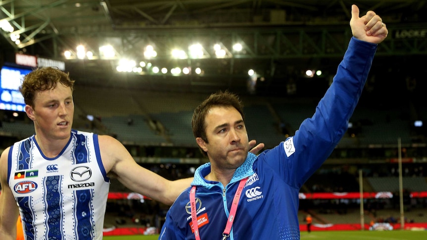 Brad Scott raises his right arm and gives the thumbs up to the Docklands crowd.