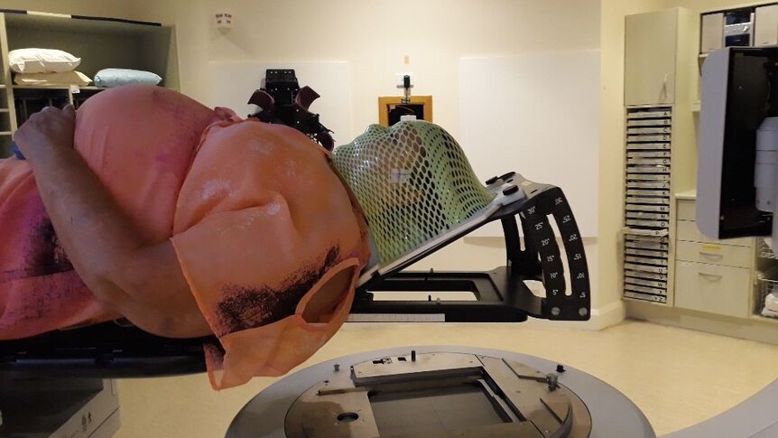 A woman lies in hospital before radiation therapy.