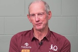 Wayne Bennett in a Queensland Rugby League polo shirt in front of a brick wall.