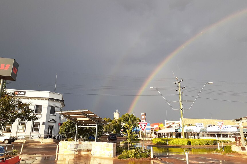 Double rainbow against storm clouds over Eagle Street in Longreach.