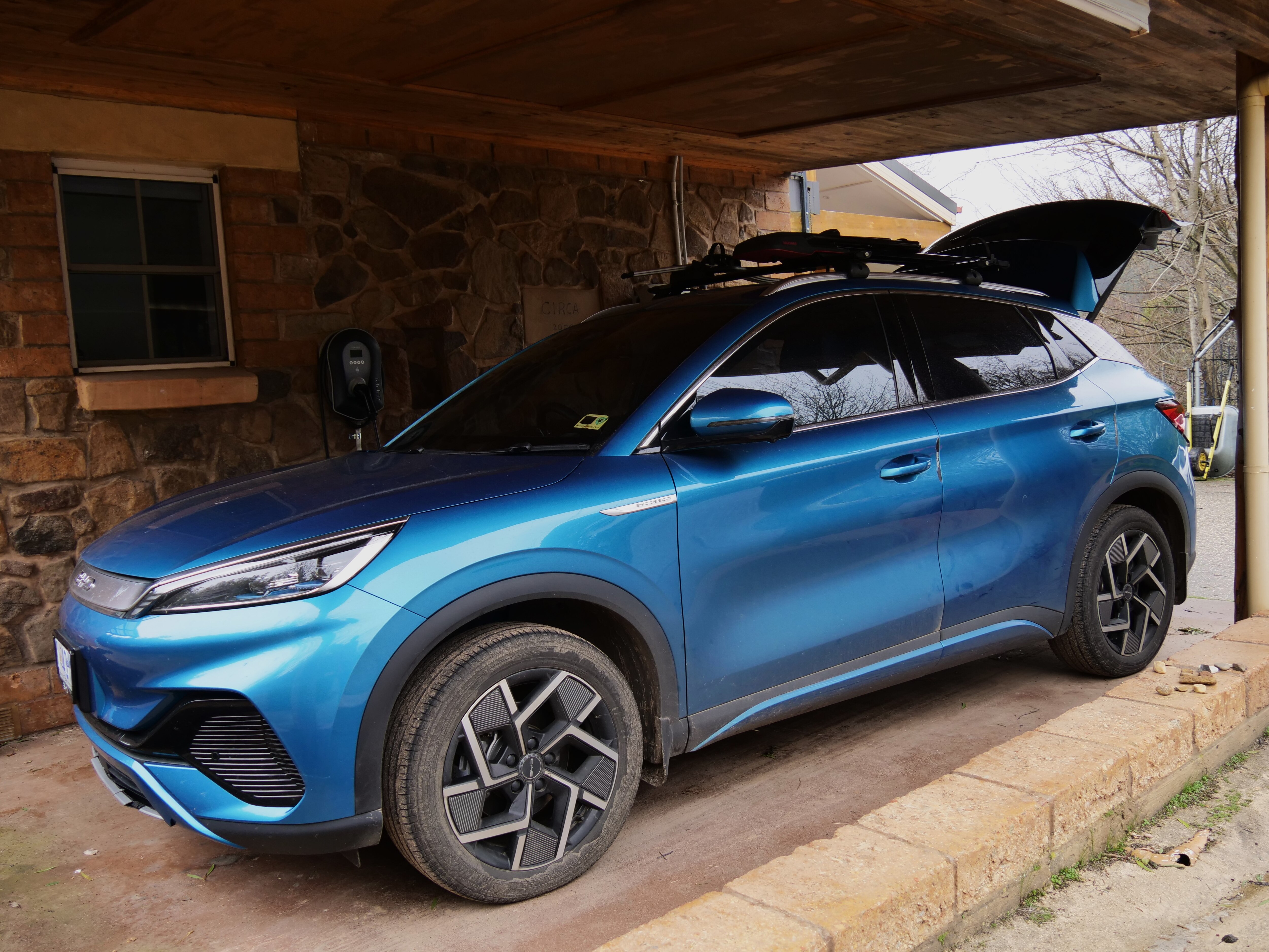 A blue electric car sitting in a garage.