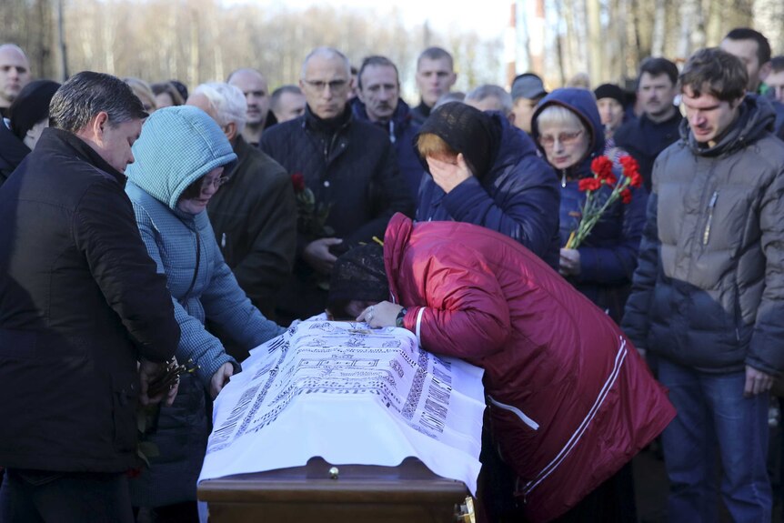 Relatives mourn next to a coffin of a victim of a Russian airliner crash in Egypt
