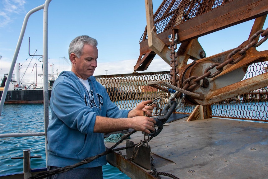 Scallop fisher Andrew Zapantis works on his ship in port.