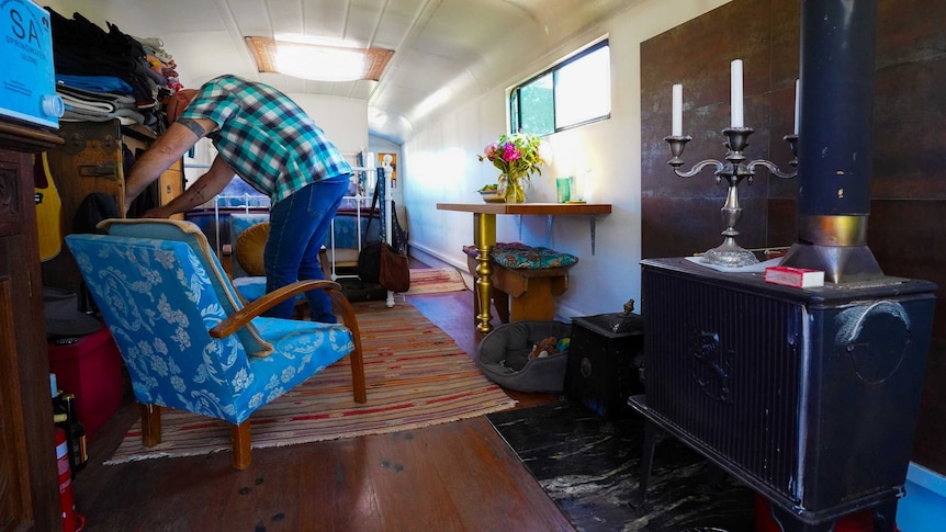 Brenton Lynch-Rhodes adjusts a cushion inside the light and roomy converted school bus.