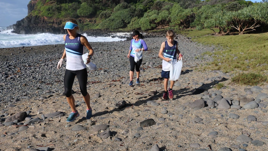 Runners pick up rubbish on a beach in northern NSW.