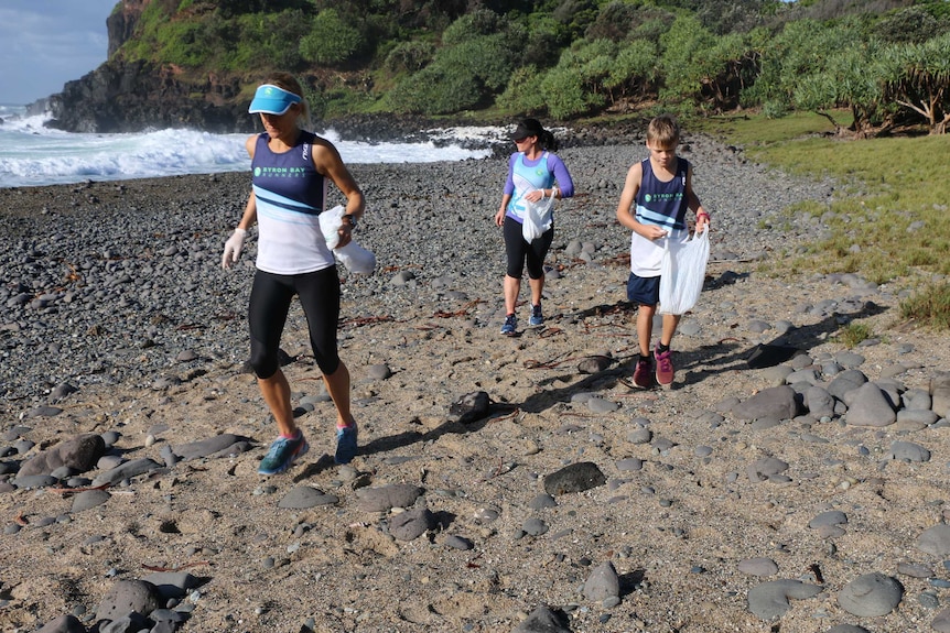 Runners pick up rubbish on a beach in northern NSW.