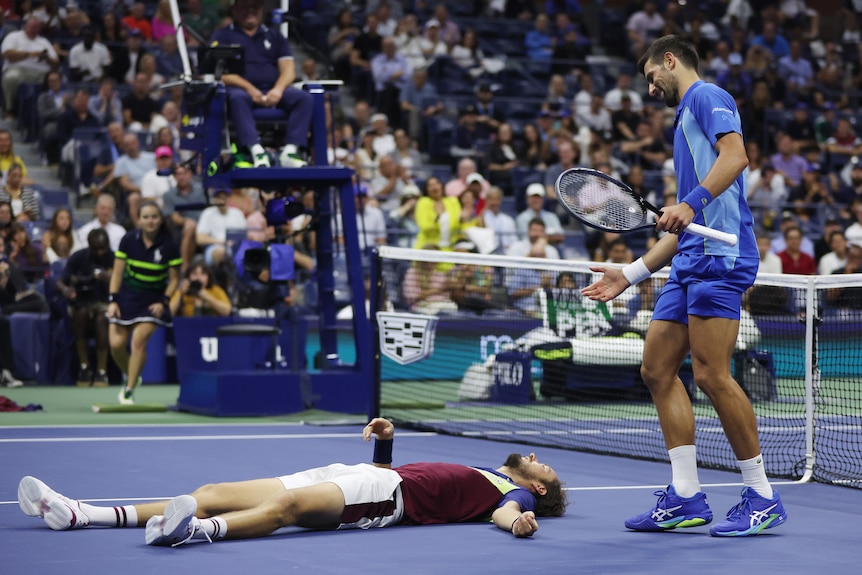 Novak Djokovic stands over Daniil Medvedev