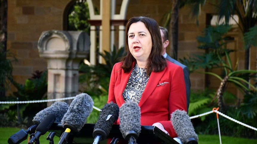 Annastacia Palaszczuk speaks at a lectern with several microphones in front at a media conference in Brisbane.