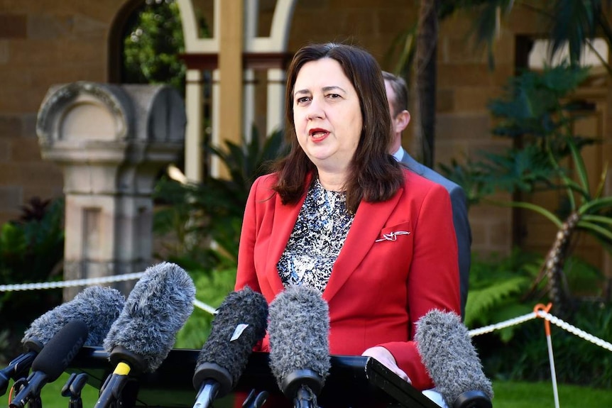 Annastacia Palaszczuk speaks at a lectern with several microphones in front at a media conference in Brisbane.