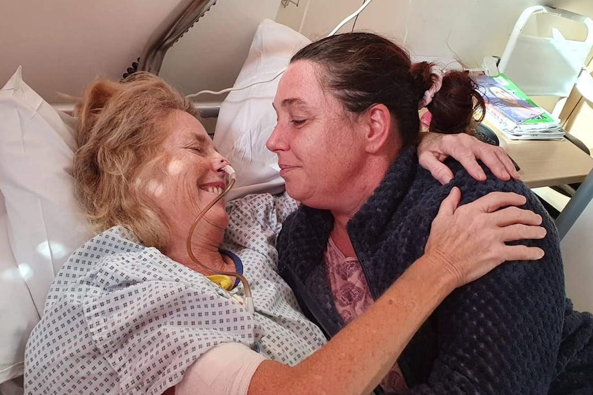 Saskia Kleijn hugs her ill mother who lies in a hospital bed