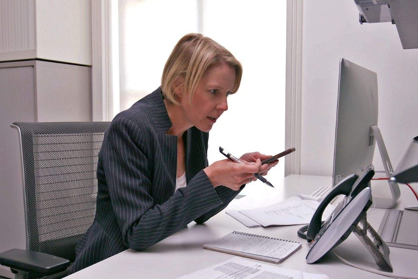 Samantha Hawley preparing to make a phone call at her desk.