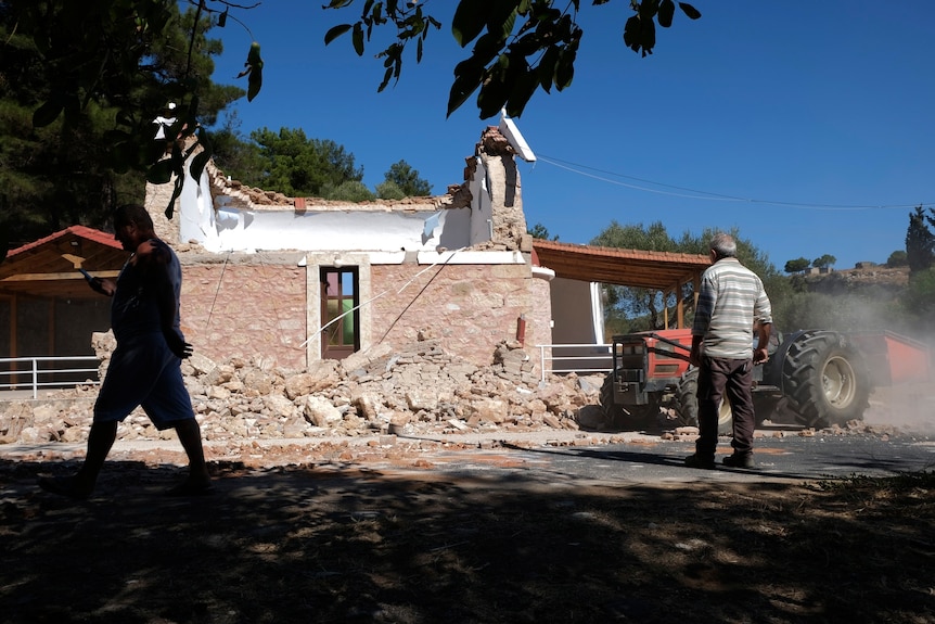 Residents pass by a destroyed chapel on the Greek island of Crete after a strong earthquake hit.